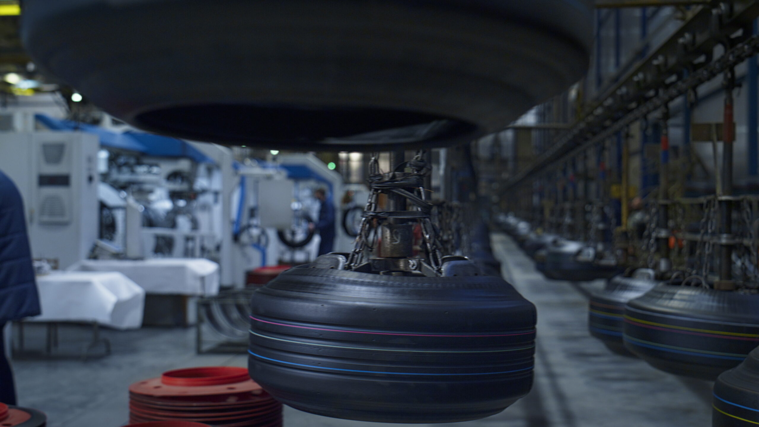 Tire production plant workers at storage facility working with modern machines